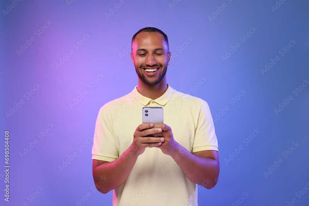 Poster happy man sending message via smartphone on color background