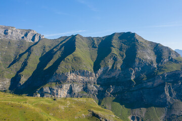 The Mountains around Gavarnie Gedre in the arid green countryside , Europe, France, Occitanie, Hautes-Pyrenees, in summer on a sunny day.