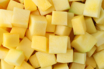Many delicious mango cubes as background, closeup