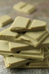 Stacked pieces of tasty matcha chocolate on textured table, closeup