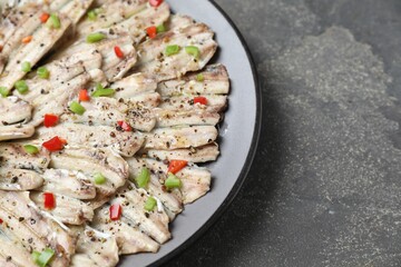 Tasty pickled anchovies with spices on grey textured table, closeup. Space for text