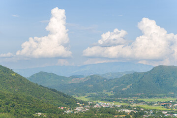A city in the valley among green rice fields and green mountains, Asia, Vietnam, Tonkin, between Son La and Dien Bien Phu, in summer on a sunny day.