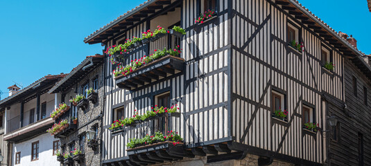 Arquitectura tradicional casas con fachada de vigas de madera y balcones adornados con macetas y...