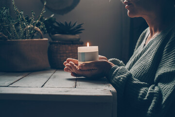 Christian woman kneeling and praying near candles. He seeks guidance in his religious faith and...