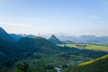 The green rice fields in the middle of the mountains in the valley, Asia, Vietnam, Tonkin, towards Hanoi, Mai Chau, in summer, on a sunny day.