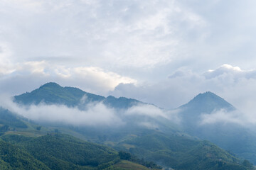 The green mountains, in Asia, in Vietnam, in Tonkin, in Sapa, towards Lao Cai, in summer, on a cloudy day.