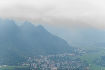 A panoramic view of the city and the green countryside among the mountains, in Asia, Vietnam, Tonkin, towards Hanoi, Mai Chau, in summer, on a cloudy day.