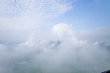 The valley dominated by clouds and fog in the middle of the mountains, in Asia, in Vietnam, in Tonkin, towards Hanoi, in Mai Chau, in summer, on a sunny day.