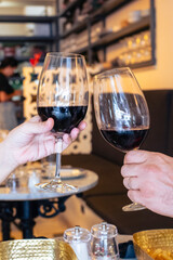 Beautiful wedding couple with glasses of red wine in pub restaurant toasting to celebrate. Free time concept