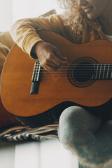 One woman at home playing guitar and having fun alone in relax leisure activity. People play music...