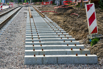 New tram rail track construction site with concrete sleepers on rubble base