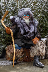 An elderly gray-haired man with a magnificent mustache and beard looks into the distance and...
