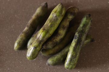 Bunch of Kewach or kenwach bean or thick french beans lying on the brown marble floor, scrambled