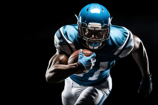 Portrait of American football player running with the ball. Muscular athlete in a blue and white uniform with an ovoid ball in a dynamic pose. Isolated on black background. - Powered by Adobe