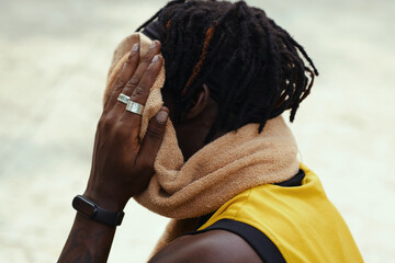 Black streetball player wiping off sweat from face after game