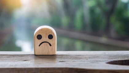 A wooden toy with sad face alone concept of loneliness and depression, unrequited love, parting or divorce - obrazy, fototapety, plakaty