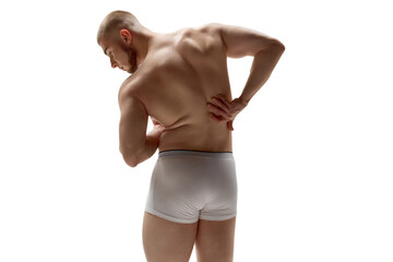 Fototapeta premium Sculpted muscles and confidence. Back view portrait of young handsome man with perfect body curves against white studio background. Concept of natural beauty, male health, fashion.