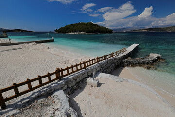 Bathing piers entering in the sand, Rilinda beach facing the bay between the mainland and the islets, Ksamil village. Sarande-Albania-172