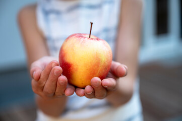 Hand of a child holding an apple