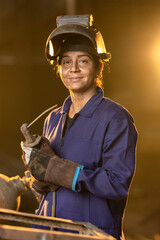 Woman welder in metalworking workshop