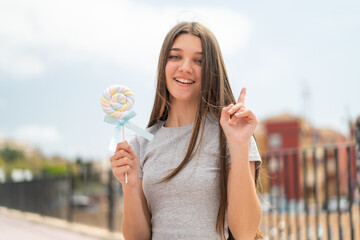 Teenager girl holding a lollipop pointing up a great idea