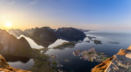The sun hangs low in the expansive sky over Reinebringen, offering a super panorama of Lofoten...