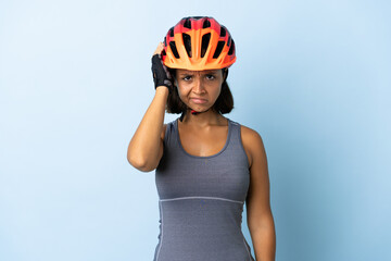 Young cyclist woman isolated on blue background with an expression of frustration and not understanding - obrazy, fototapety, plakaty
