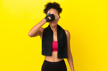 Young African sport woman isolated on yellow background covering eyes by hands. Do not want to see...