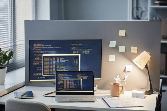 Background image of clean office workplace setting with code lines on computer screens, copy space
