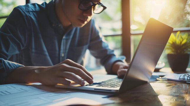 Paperwork And Asian Man Planning With A Laptop For Finance, Insurance And Tax. Payment, Note And Japanese Entrepreneur Reading Information On A Contract To Start A Small Business From Home