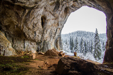 Gorgeous winter mountain panorama showcasing snow-capped peaks, serene valleys, and icy streams against a crisp blue sky backdrop.
