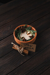 The candle is decorated with green décor and a new year inscription