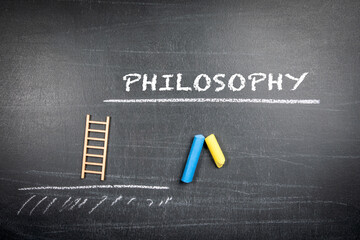 Philosophy Concept. Text and pieces of chalk on a dark chalkboard background
