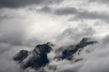 Mountainous expanse cloaked in mist.