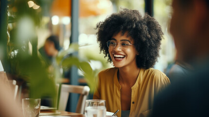 Black afro American business woman having a friendly lunch with colleagues at a local cafe, she engages in casual conversation, fostering a positive and collaborative atmosphere