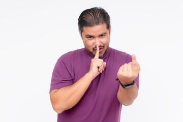 A funny looking guy tells someone to stay quiet while gesturing to come closer. Wearing a purple shirt, isolated on a white background.