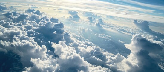Sky view from airplane window with fluffy white clouds on sunny day.