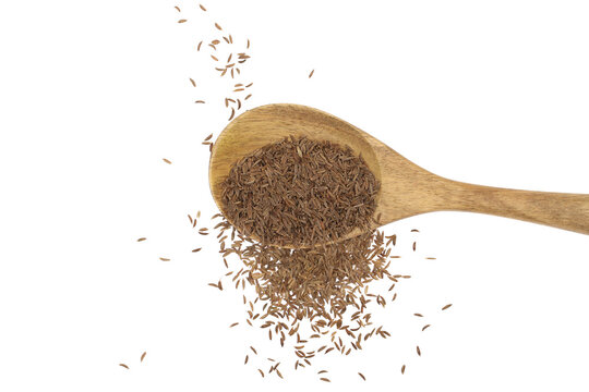 Pile of cumin, caraway seeds in wooden spoon isolated on white, top view