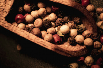 Different kind of Peppercorns in a wooden spoon.Different kind of Peppercorns in a wooden spoon