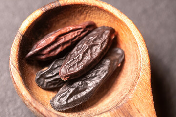 Tonka Beans in a wooden Spoon on a dark background