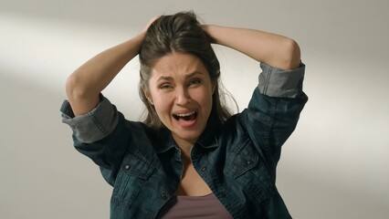 Portrait of appealing female model in friendly mood. Brunette woman in casual on white background in the studio hysterically laughing at camera.