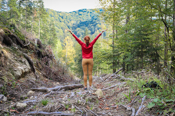 a woman meditates, breathes deeply near the mountains