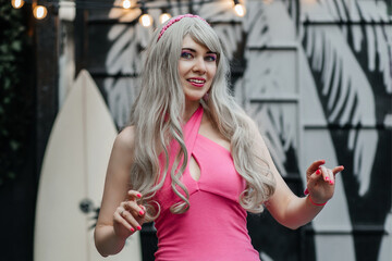 Young beautiful woman with blond hair in a pink dress