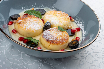Cheesecakes with сustard and grapes with mint on white background