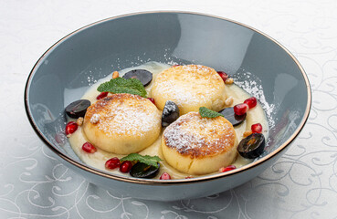 Cheesecakes with сustard and grapes with mint on white background