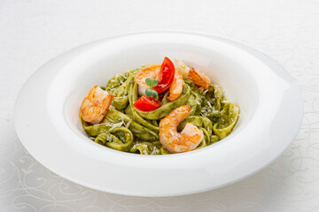 Fettuccini with shrimp and pesto sauce. Isolated image