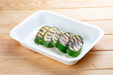 Grilled zucchini. Healthly food. Takeaway food. On a wooden background.