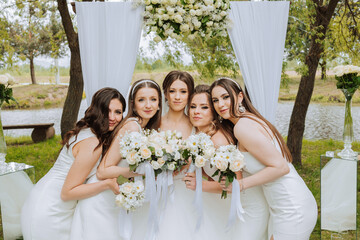 Group portrait of the bride and bridesmaids. Bride in a wedding dress and bridesmaids in white...