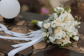 A bouquet of white roses stands on a wooden background. Cropped photo. Details at the wedding.