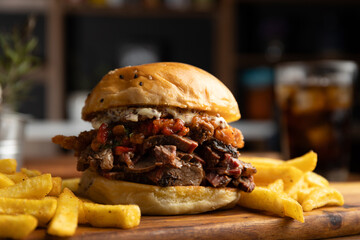 Brisket sandwich with sweet pepper, caramelized onion and aioli sauce served with a portion of...